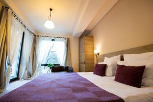 a bedroom with a large bed with a christmas tree in the window at GreenHill Brasov in Braşov
