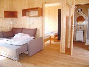 een slaapkamer met een bed en een kamer met een spiegel bij Domki Letniskowe Pikamar in Darlowko