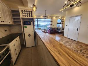 a kitchen with a counter top and a living room at Sora Addis BnB in Addis Ababa