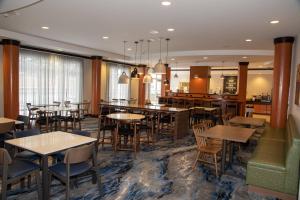 restauracja ze stołami i krzesłami oraz bar w obiekcie Fairfield Inn & Suites Lewisburg w mieście Lewisburg