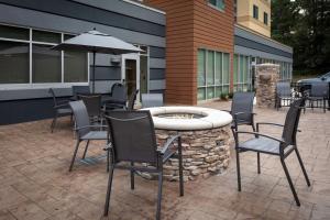 um pátio com uma mesa, cadeiras e um guarda-sol em Fairfield Inn & Suites by Marriott Atlanta Marietta em Marietta