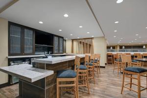 a lobby with a bar with chairs and tables at TownePlace Suites By Marriott Lima in Lima