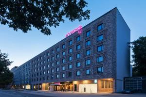 ein Hotelgebäude mit einem rosa Schild darauf in der Unterkunft Moxy Hamburg City in Hamburg