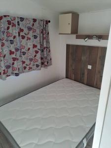 a small bedroom with a bed with a curtain at A la ferme dans le Luberon 