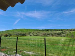 uma cerca em frente a um campo com uma colina em A la ferme dans le Luberon 