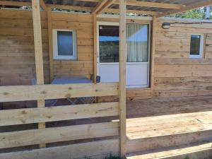 uma casa de madeira com um alpendre e duas portas em A la ferme dans le Luberon 