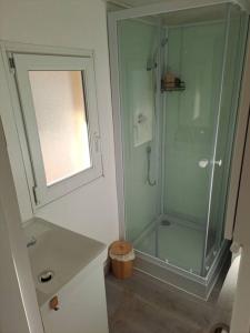 uma casa de banho com uma cabina de duche em vidro e um lavatório. em A la ferme dans le Luberon 