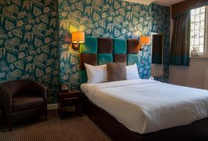 a bedroom with a large bed and a chair at Hopping Hare in Northampton
