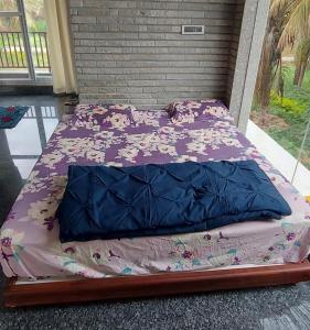 a bed with purple sheets and flowers on it at Kashi Farm House in Channarāyapatna