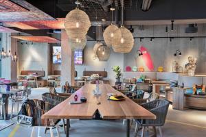 a restaurant with a large wooden table and chairs at Moxy Hamburg City in Hamburg