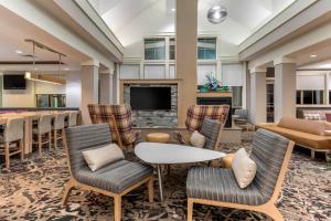 um átrio com uma mesa e cadeiras e uma lareira em Residence Inn Columbus em Columbus