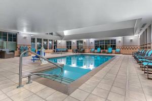 uma piscina num hotel com cadeiras e mesas em Residence Inn Columbus em Columbus