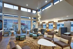 een grote lobby met stoelen, tafels en ramen bij Residence Inn by Marriott Provo South University in Provo