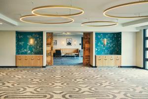 a large room with blue walls and wooden cabinets and a lobby at The Draftsman, Autograph Collection in Charlottesville