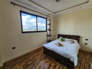 a bedroom with a bed with a large window at Sora Addis BnB in Addis Ababa