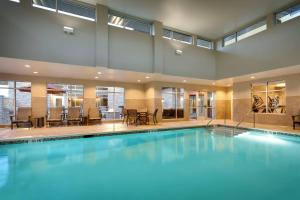 a large swimming pool with blue water in a building at Residence Inn by Marriott Provo South University in Provo