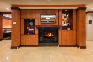 ein Wohnzimmer mit einem Kamin und einem TV in der Unterkunft Fairfield Inn and Suites by Marriott Augusta in Augusta