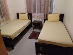 Pokój z 2 łóżkami, stołem i zasłonami w obiekcie Villa Saraya w mieście Mehdiya-Plage