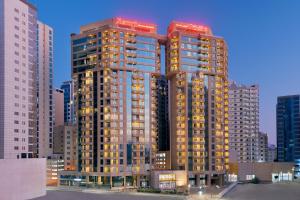 two tall buildings in a city at night at Marriott Executive Apartments Manama, Bahrain in Manama