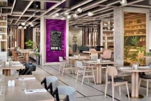 a restaurant with tables and chairs and purple walls at Marriott Executive Apartments Manama, Bahrain in Manama