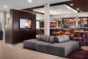 a lobby with a couch and a restaurant with tables at Courtyard by Marriott Fishkill in Fishkill