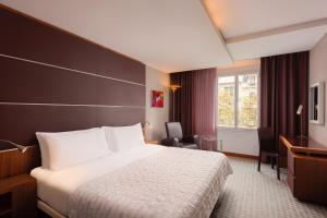 a hotel room with a bed and a window at Le Meridien Barcelona in Barcelona