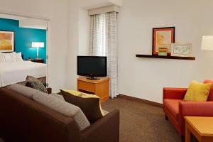 a hotel room with a bed and a flat screen tv at Residence Inn Detroit Troy/Madison Heights in Madison Heights