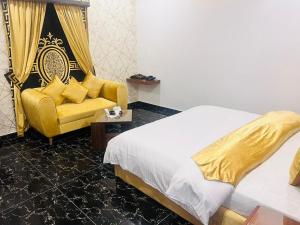 a bedroom with a bed and a yellow couch at Hotel Grace inn in Multan