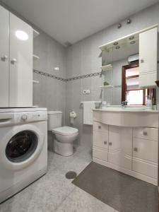 uma casa de banho com uma máquina de lavar roupa e um WC em SOLPOR em Cee
