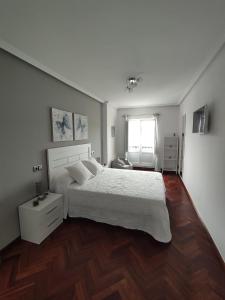 a bedroom with a white bed and a wooden floor at SOLPOR in Cee