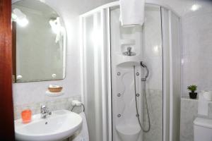 y baño con ducha y lavamanos. en Hotel Restaurante Oviedo, en Luarca