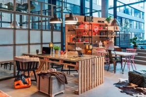 een kamer met een grote houten tafel en stoelen bij Moxy Frankfurt City Center in Frankfurt am Main