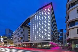 wysoki budynek z oświetleniem na boku w obiekcie Moxy Frankfurt City Center w Frankfurcie nad Menem