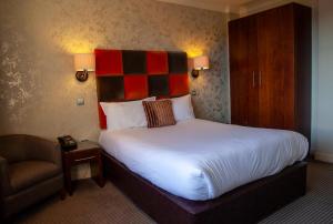 a bedroom with a bed with a red and black headboard at Hopping Hare in Northampton