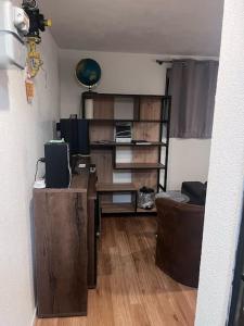 ein Wohnzimmer mit einem Schreibtisch und einem Bücherregal in der Unterkunft Kleine Wohnung im - Konzept Flieger - 2 Stockwerke in Tettnang