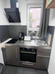 eine kleine Küche mit einer Spüle und einem Herd in der Unterkunft Kleine Wohnung im - Konzept Flieger - 2 Stockwerke in Tettnang