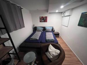 ein kleines Schlafzimmer mit einem Bett und einem Stuhl in der Unterkunft Kleine Wohnung im - Konzept Flieger - 2 Stockwerke in Tettnang