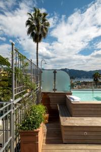 balcón con piscina y palmera en Albergo Minerva, en Santa Margherita Ligure