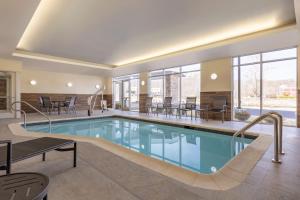 a pool in a hotel with chairs and tables at Fairfield by Marriott Inn & Suites Rockaway in Rockaway