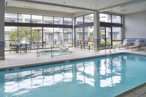 a pool with tables and chairs in a building at Courtyard by Marriott Detroit Troy in Troy