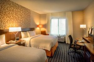 um quarto de hotel com duas camas e uma secretária e uma janela em Fairfield Inn & Suites Dulles Airport em Sterling