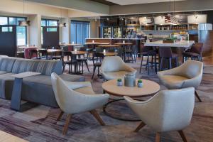 a restaurant with chairs and tables and a bar at Courtyard by Marriott Detroit Troy in Troy