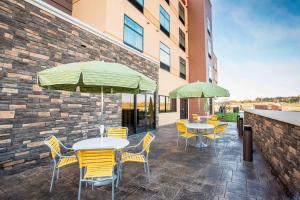 a patio with tables and chairs and umbrellas at Fairfield Inn & Suites By Marriott Sioux Falls Airport in Sioux Falls