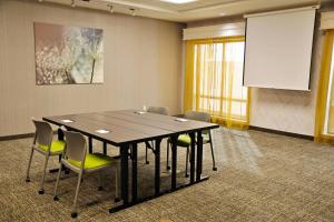 een vergaderzaal met een tafel en stoelen en een projectiescherm bij SpringHill Suites Houston Katy Mills in Katy