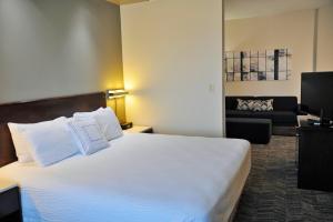 a hotel room with a large bed and a couch at SpringHill Suites Houston Katy Mills in Katy