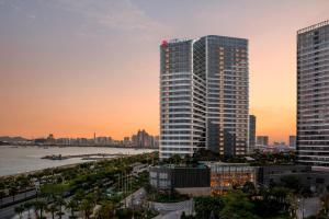 a rendering of a tall building with a city at Xiamen Marriott Hotel Haicang in Xiamen