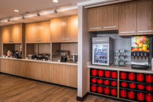 a kitchen with a counter with red bowls and a refrigerator at TownePlace Suites by Marriott Merced in Merced