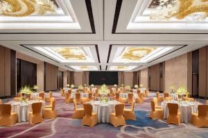a large room with tables and chairs and ceilings at Xiamen Marriott Hotel Haicang in Xiamen