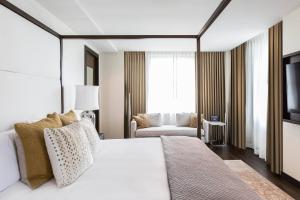 a bedroom with a large white bed and a chair at JW Marriott Houston Downtown in Houston +125 photos