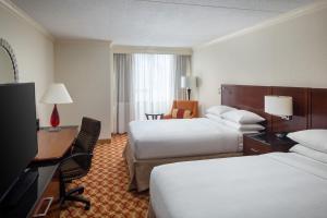 a hotel room with two beds and a desk at Indianapolis Marriott East in Indianapolis